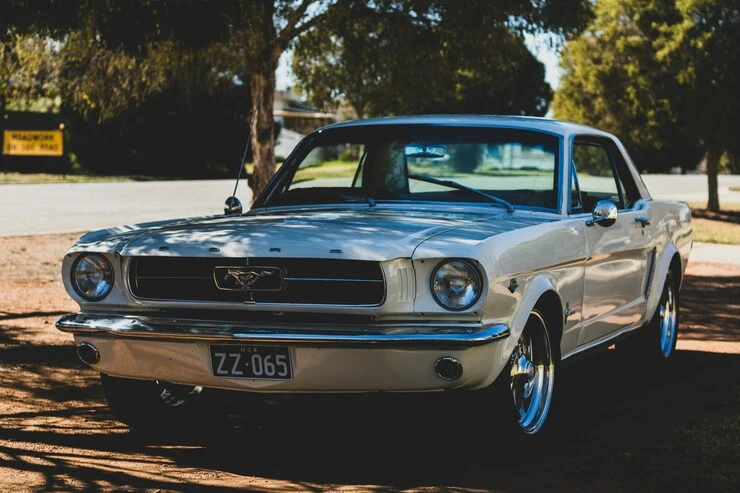 White 1965 Ford Mustang coupe photographed outdoors.