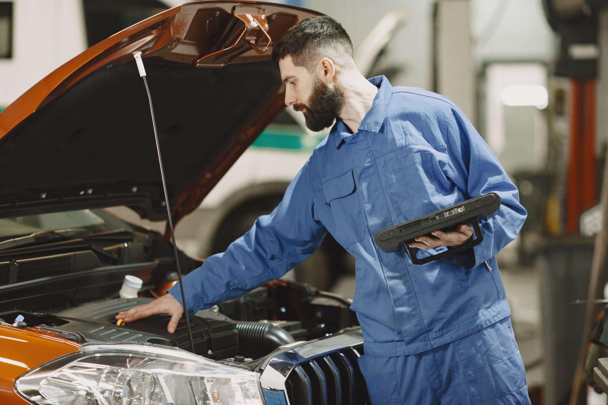 Mechanic inspecting a car engine in a workshop