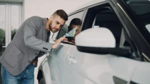 Car buyer examining a new vehicle in a dealership showroom