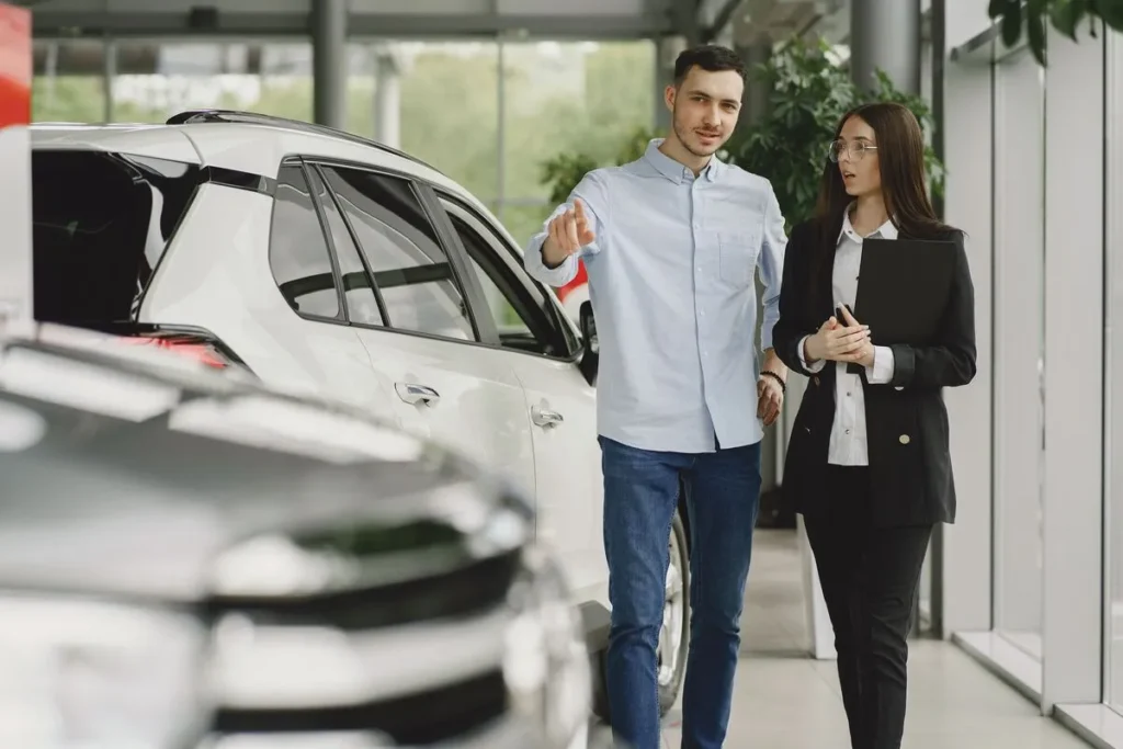Customer and salesperson discussing a vehicle inside a car dealership