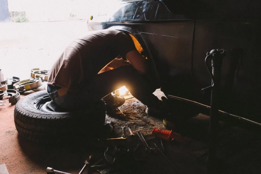 Mechanic working on a car wheel in a repair workshop