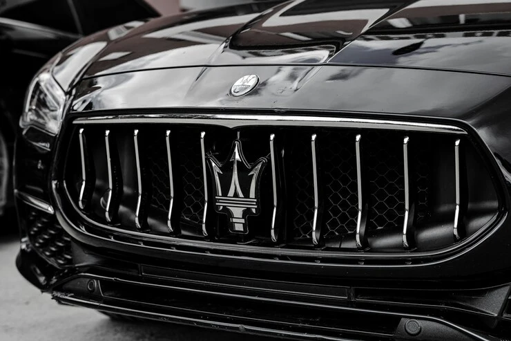 Close-up of the Maserati trident badge on a car's front grille