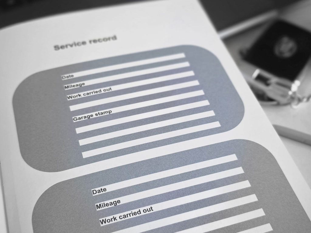 Car service book showing date, mileage, work carried out and garage stamp fields