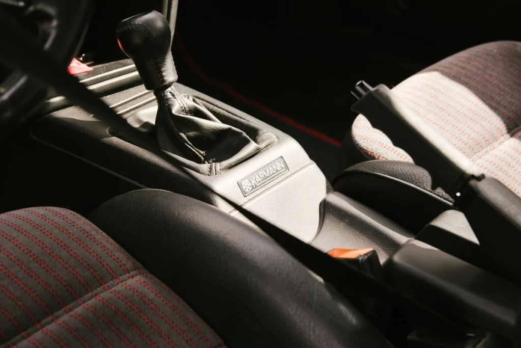 Traditional manual handbrake lever between the front seats of a car